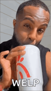 a man is drinking from a chick-fil-a cup while making a funny face .