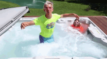 a boy and a girl are playing in a hot tub . the boy is wearing a neon green shirt .