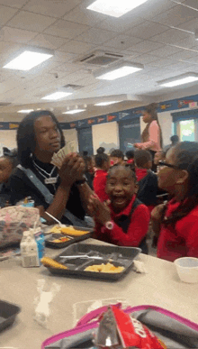 a man is holding a bunch of money in front of a group of kids