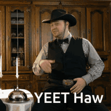 a man in a cowboy hat is sitting at a table with the words yeet haw written on the bottom