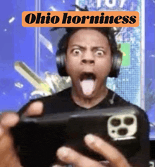 a man wearing headphones is holding a cell phone with the words ohio horniness written above him
