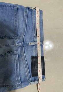 a pair of levi 's jeans are being measured by a tape measure