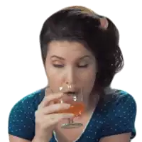 a woman in a blue shirt drinks from a glass