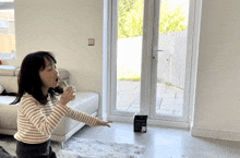 a little girl is drinking from a glass in a living room