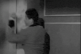 a black and white photo of a man in a military uniform dancing .