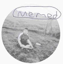 a black and white photo of a boy sitting in the grass with the word memed written on it