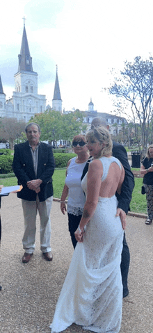 a bride and groom are posing for a picture in front of a cathedral