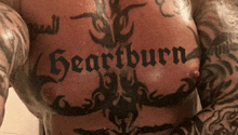 a man has a tattoo on his chest that says " heartburn "