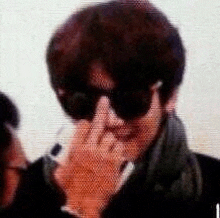 a blurry picture of a man wearing sunglasses covering his face .