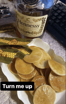a bottle of hennessy sits next to pancakes and honey