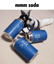 a stuffed animal is laying on the floor next to a pile of soda cans