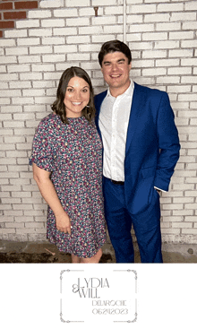 a man in a blue suit and a woman in a blue dress pose for a picture