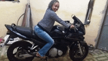 a woman is sitting on a black motorcycle with the word suzuki on it