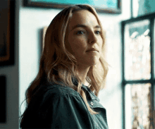 a close up of a woman 's face with a window in the background