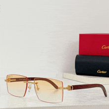 a pair of cartier sunglasses sits on a shelf next to a cartier box