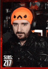 a man with a beard wearing headphones and an orange headband that says subs 217