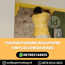 a man in a yellow shirt is installing a wallpaper