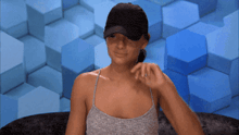 a woman wearing a hat is sitting in front of blue cubes