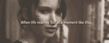 a black and white photo of a woman with the words " when life reaches out at a moment like this " below her