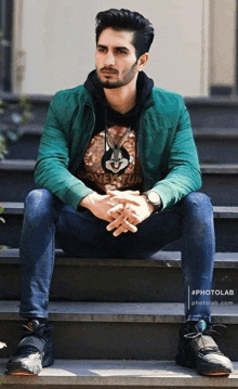 a man wearing a green jacket and a bunny rabbit t-shirt sits on a set of steps