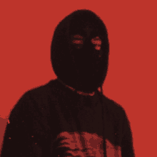 a man wearing a black hoodie and a black mask on his face