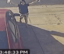 a man is standing next to a red car on the sidewalk .