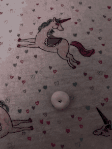 a fabric with unicorns and hearts on it and a button