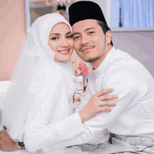 a bride and groom are posing for a picture and the bride is wearing a ring on her finger