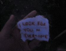 a hand holding a piece of paper that says i look for you in everyone