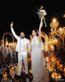 a bride and groom are celebrating their wedding with a bouquet of flowers in their hands