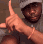 a man in a hat is giving a thumbs up sign .