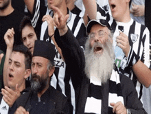 a man with a beard wearing a black and white striped shirt that says ezza