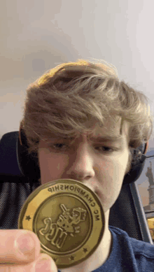 a young man is holding a coin that says hugs