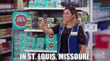 a woman is taking a selfie in a grocery store with the words `` in st. louis , missouri . ''