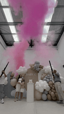 a baby shower with pink smoke and balloons