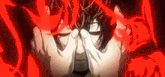 a close up of a person covering their face with their hands with red lights behind them