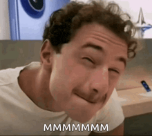 a man is making a funny face with the word mmmmm written below him