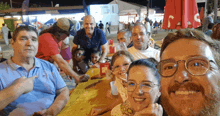 a group of people are posing for a picture in front of a sign that says ' coca cola '