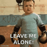 a baby is wearing boxing gloves and says leave me alone