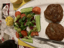 a plate of food with meat and vegetables including tomatoes cucumbers and olives