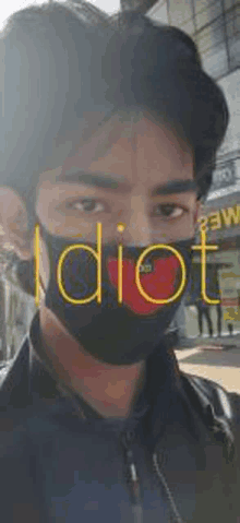 a man wearing a black face mask with the word idiot on it .