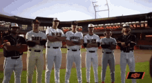 a group of baseball players are standing on a field with their arms crossed and a lsu logo in the background