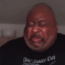 a man wearing a shirt that says ' do n't town dat ' is crying