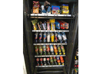 a vending machine filled with a variety of snacks including snickers and haribo