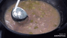 a ladle is being used to stir a pot of soup with the words made in animatica on the bottom