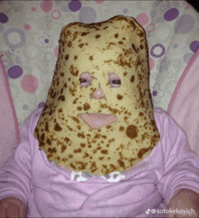 a baby is wearing a pancake mask on her face