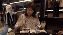 a woman sits at a table with plates of food and a glass of orange juice in front of her