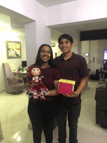 a man and a woman are posing for a picture while the woman holds a doll