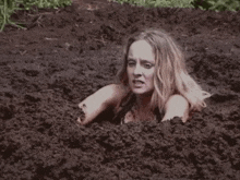 a woman is buried in a pile of mud .