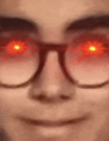 a close up of a person wearing glasses with red lights coming out of their eyes .